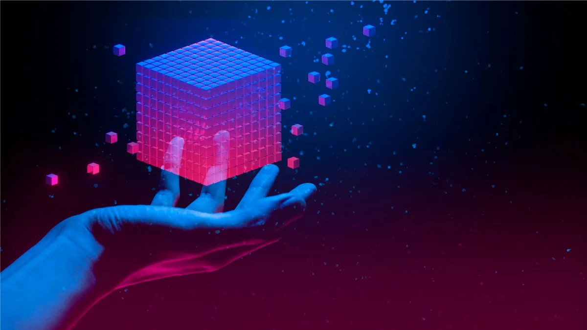 Hand holding holographic 3D cube with floating digital particles representing future modeling trends